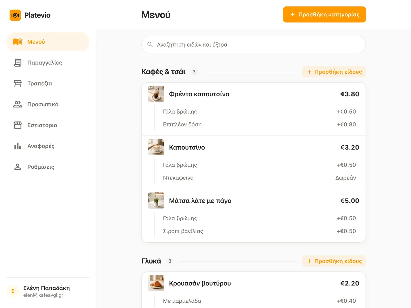 Ο κατάλογος μιας καφετέριας ανοιχτός στο Platevio, σε ένα tablet πάνω στον πάγκο, με φωτογραφίες, τιμές και extras