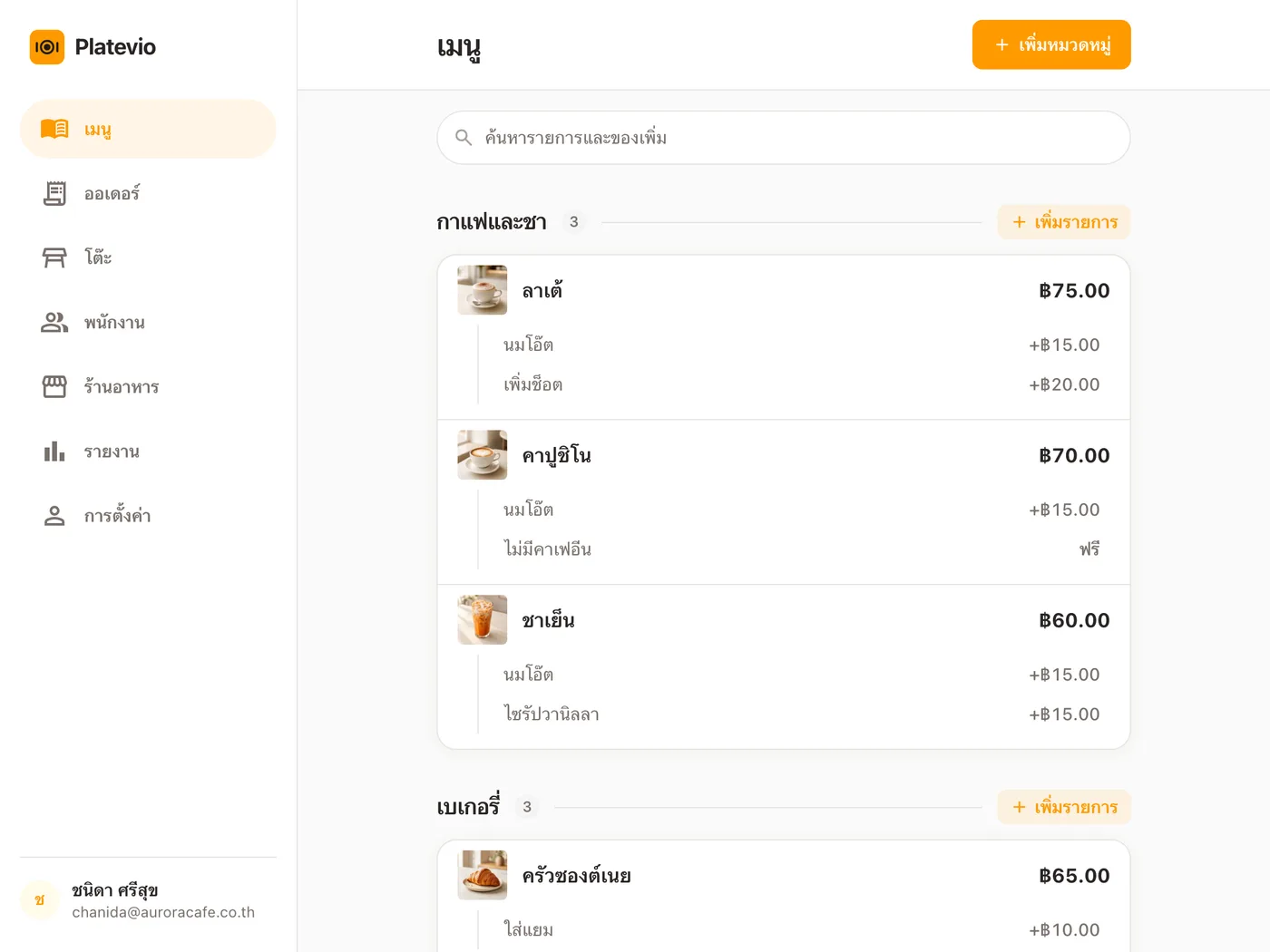 เมนูร้านกาแฟเปิดอยู่ใน Platevio บนแท็บเล็ตที่วางบนเคาน์เตอร์ พร้อมรูป ราคา และตัวเลือกเพิ่ม