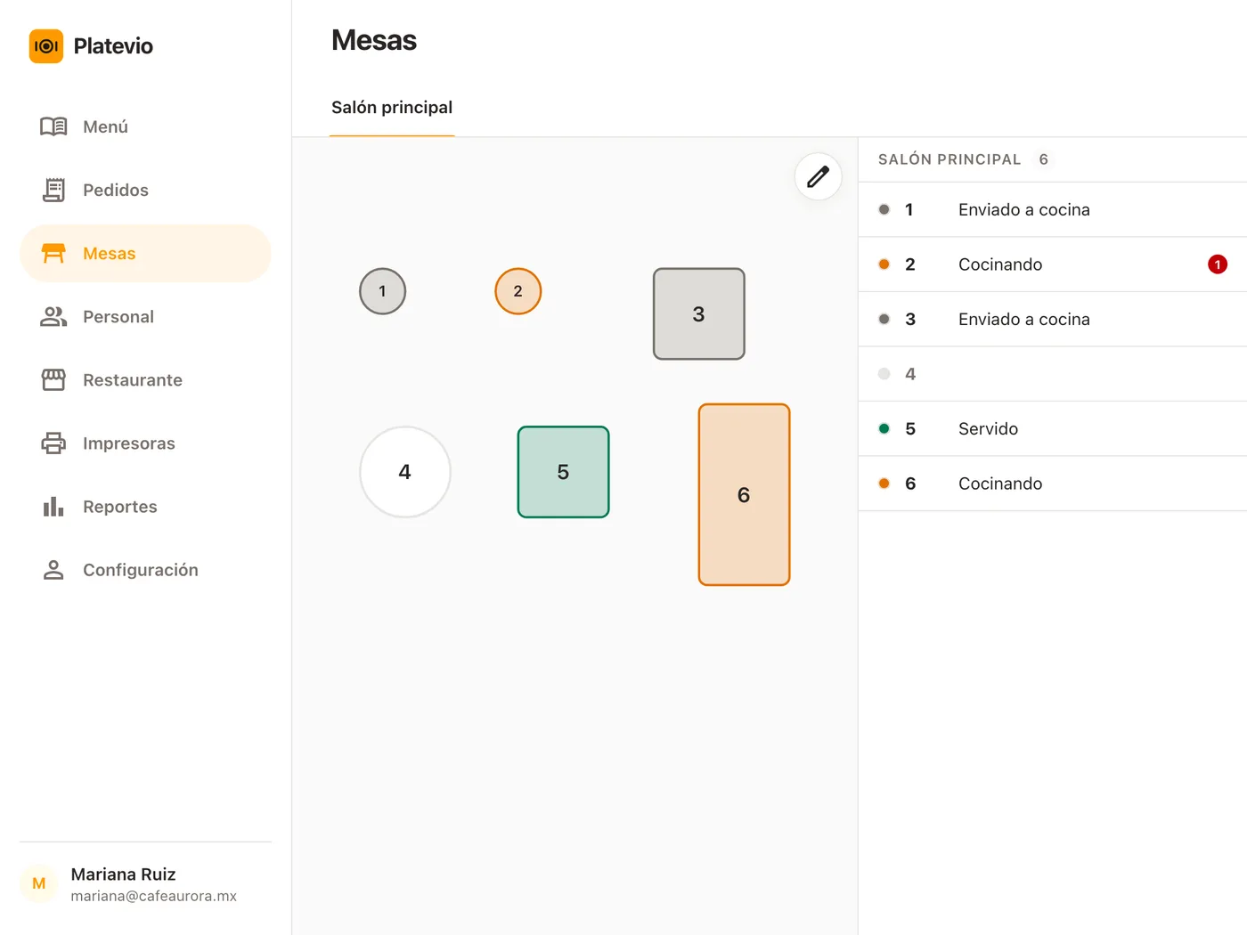 La pantalla Mesas de Platevio en una tableta: las seis mesas del salón principal, cinco dibujadas en el color de su estado, y al lado la lista que lee Enviado a cocina, Cocinando y Servido, con un platillo contado en el pase